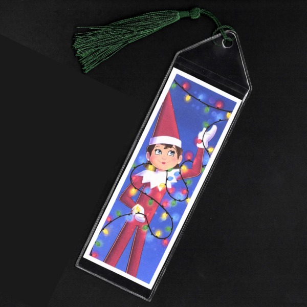 Blue-eyed girl Elf on the Shelf bookmark with green tassel by L.C. Ireland, accordingtolc